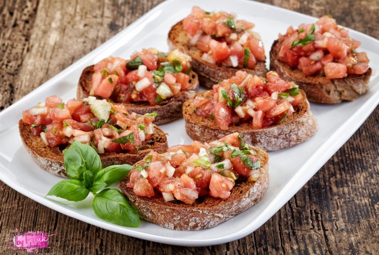 bruschetta on white plate with visible vegetables set to look pretty