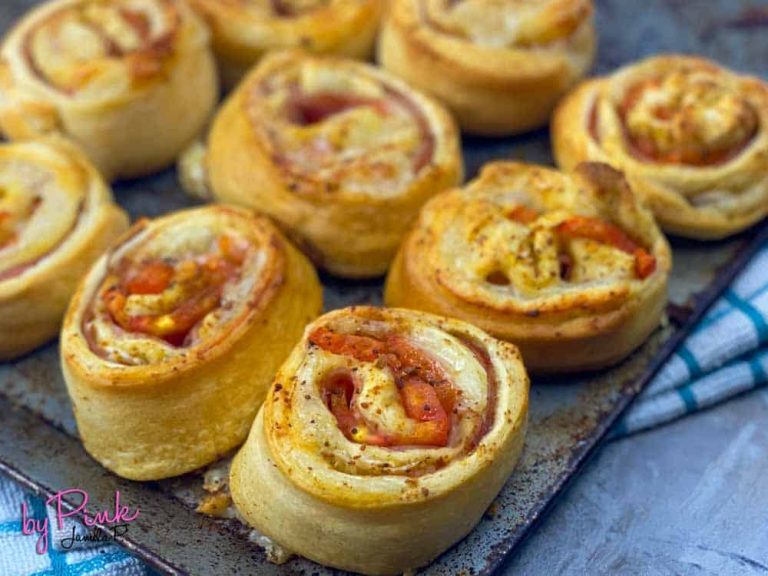 close up of ham and swiss pinwheel sandwiches on a baking sheet