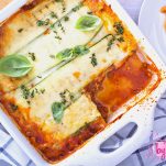 Top View Of Zucchini Lasagna In A White Dish with blue and white striped towel