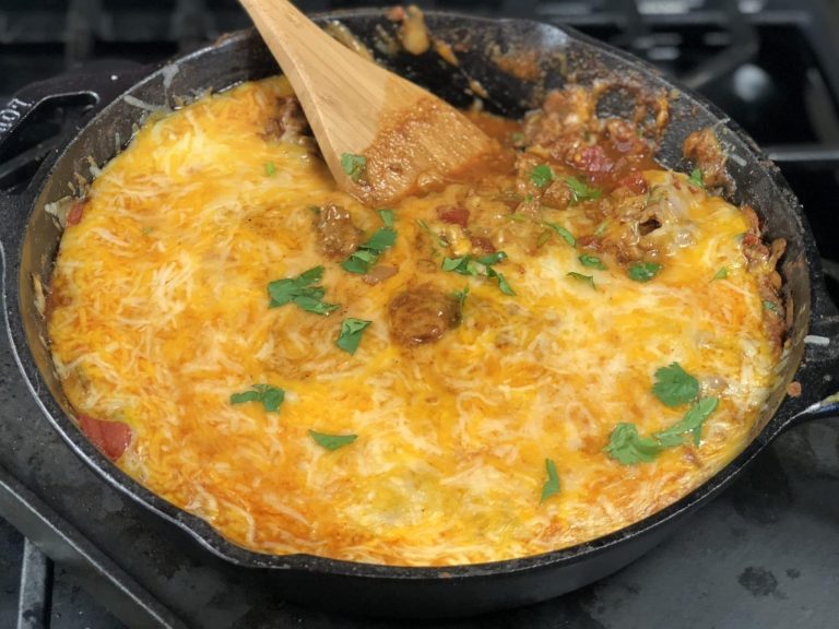 cheesy taco skillet with wooden spoon sticking out of a skillet