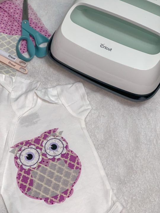 easypress 2 next to onesiees with a fabric appliqué with cricut tools and scissors in the shot