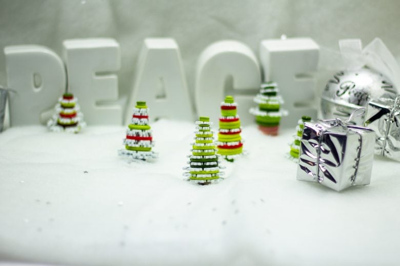 white background with the words peace and red green and white christmas tree ornaments