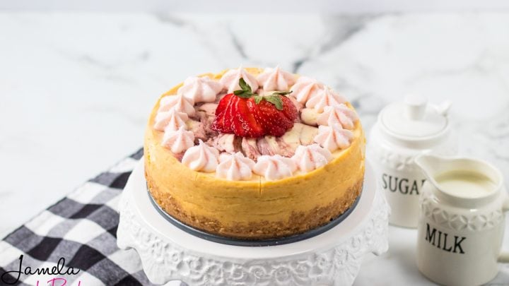 whole strawberry cheesecake on a white cake plate