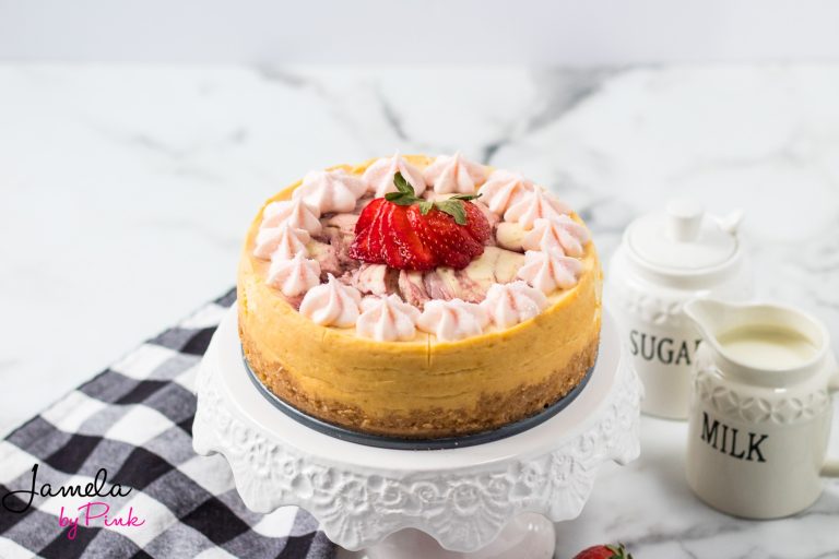 whole strawberry cheesecake on a white cake plate