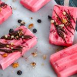 4 pink popsicles with a chocolate and walnut drizzle