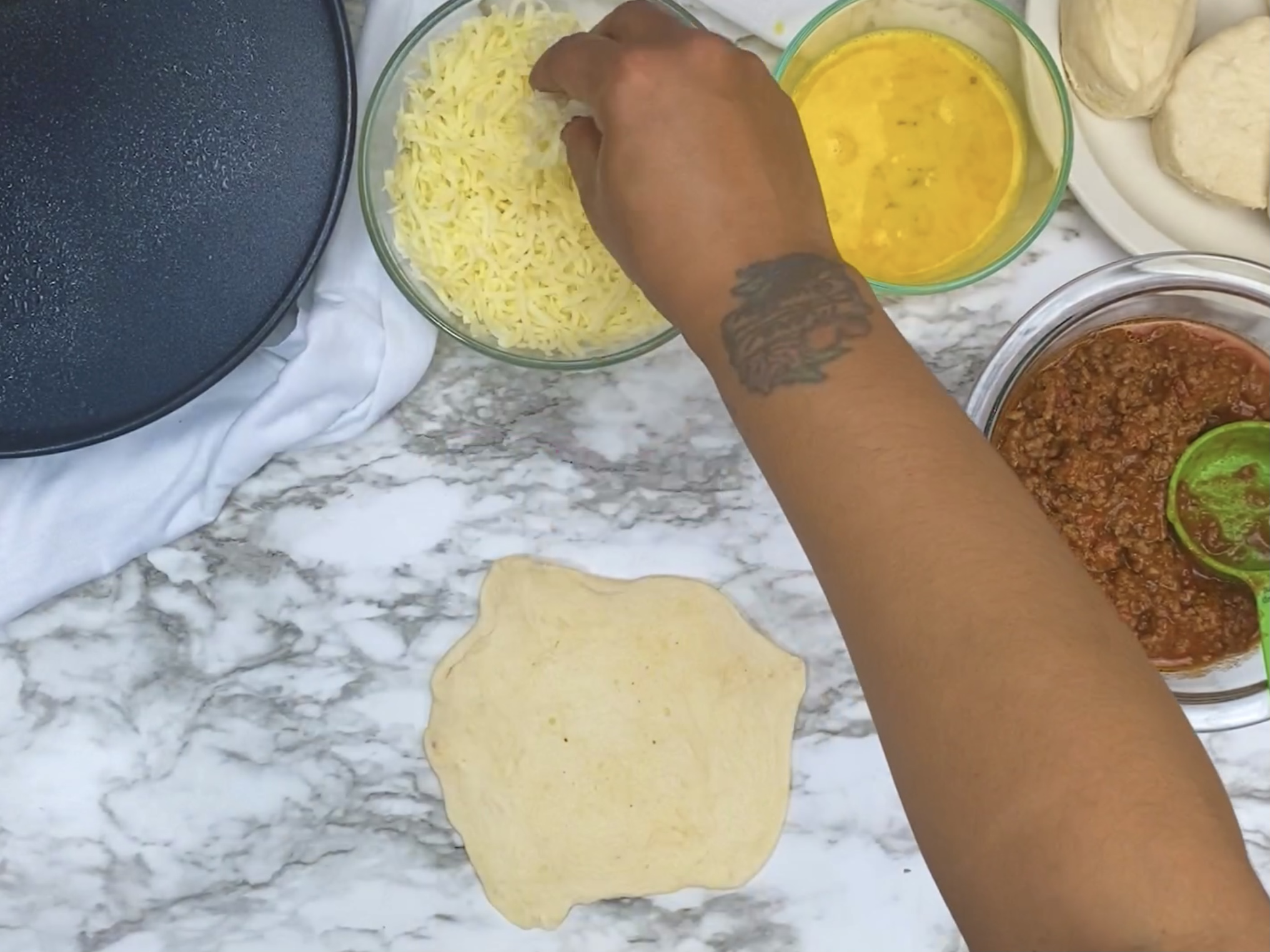 hand adding cheese to dough