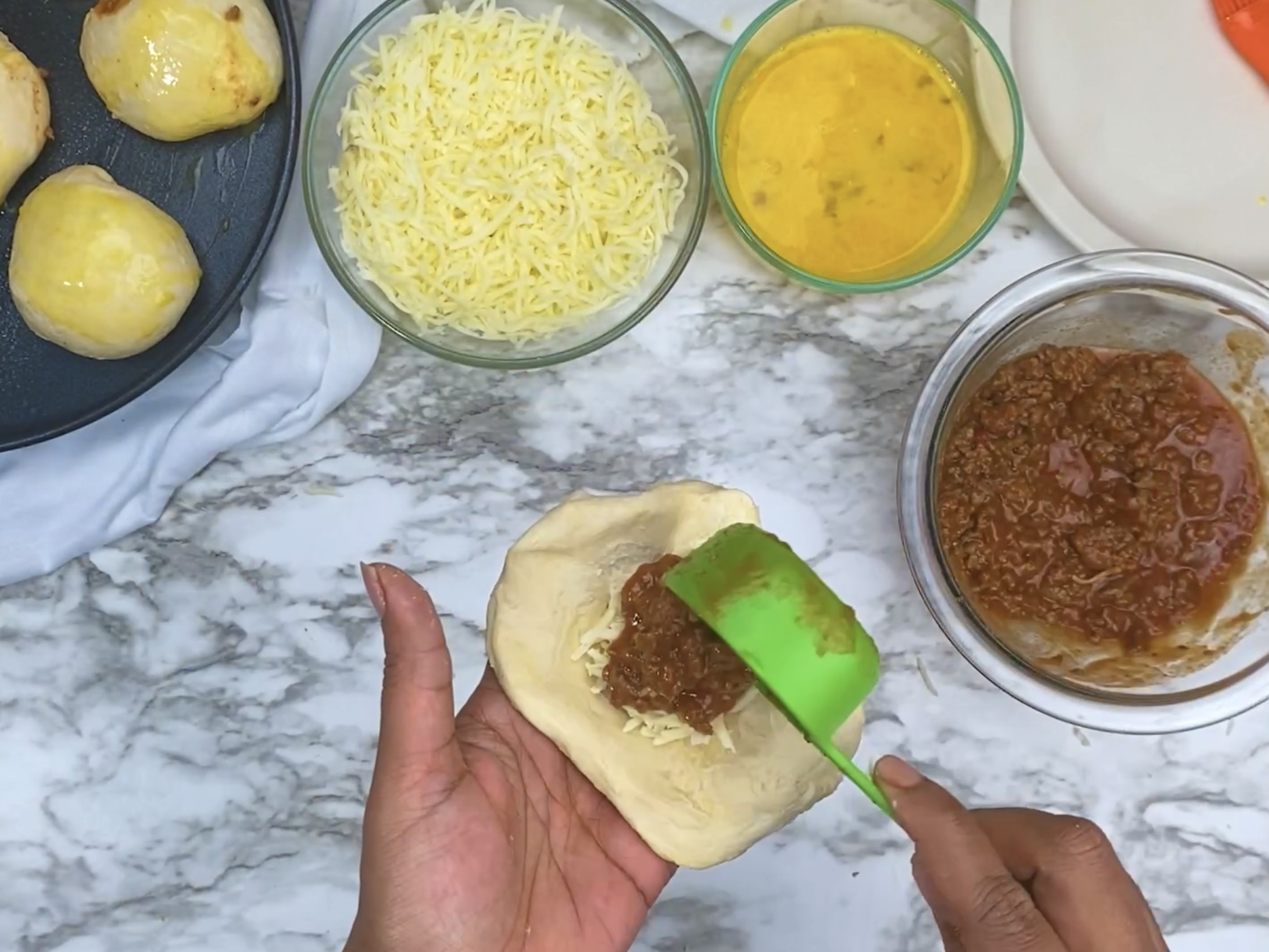 hands scooping meat into dough for manwich sloppy joe bombs