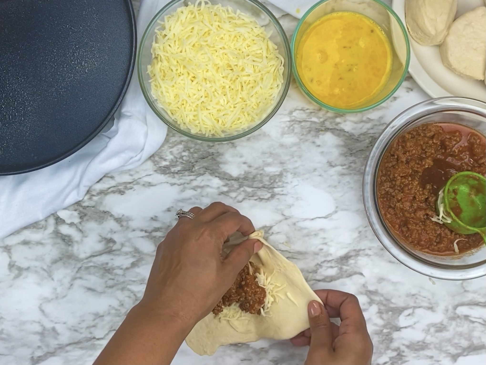 hands closing dough around manwich mixture