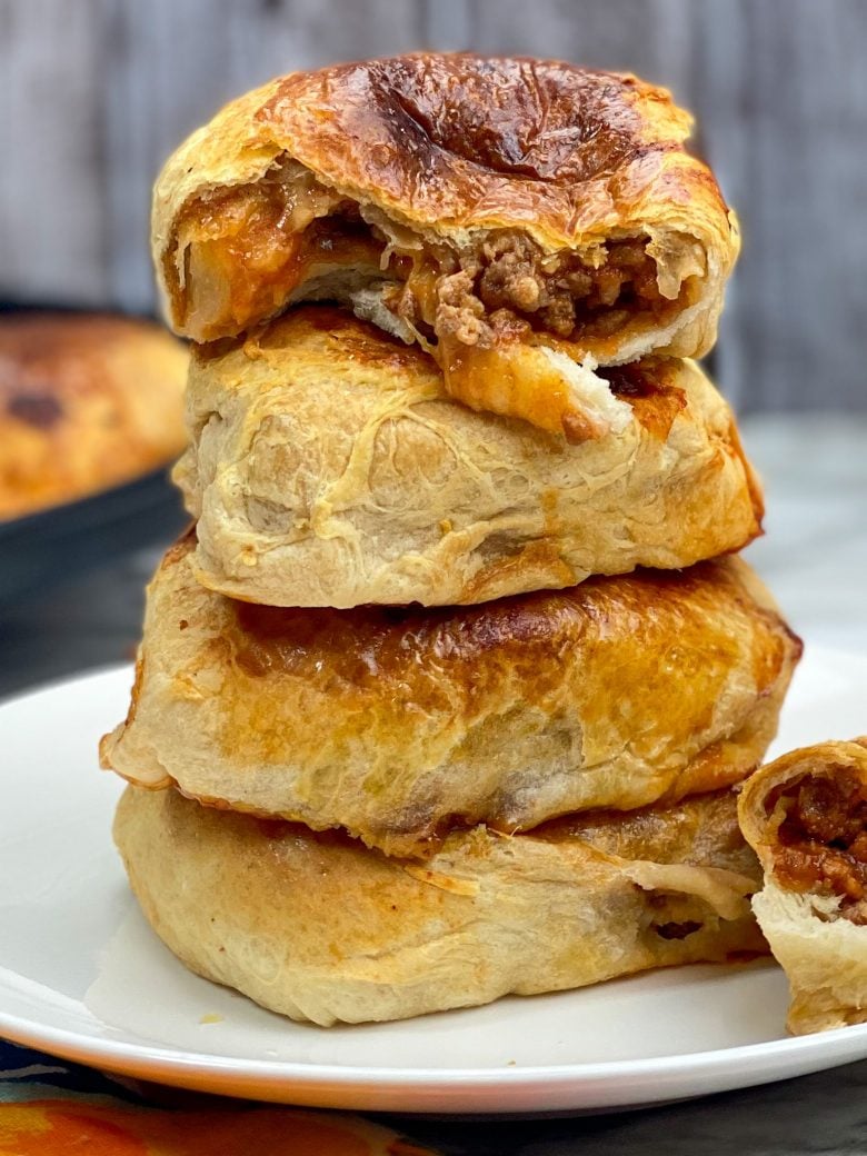 stack of four sloppy joes with top sloppy joe cut in half with ground beef and mozzarella cheese on the inside